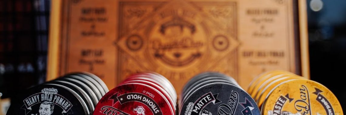 Close-up of various vintage-style hair products in a wooden box with decorative design.